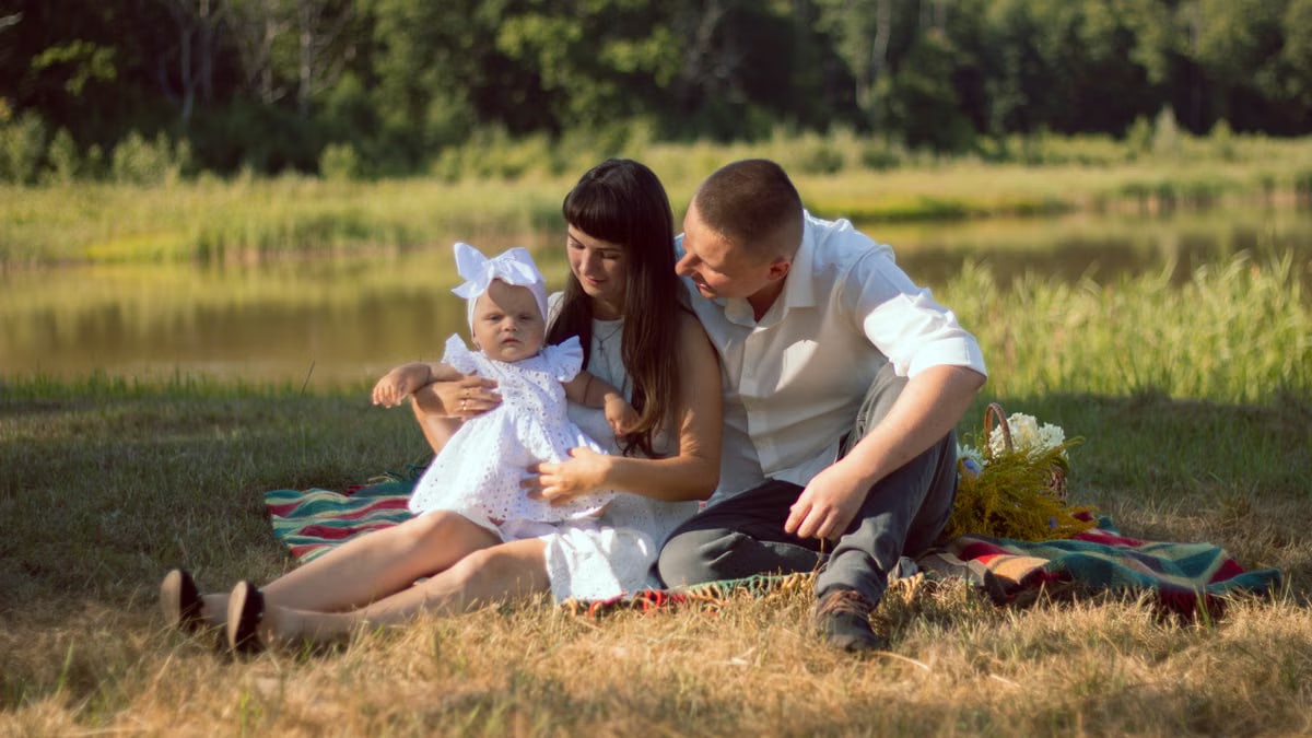 A happy family enjoys a summer picnic by a scenic lake.
